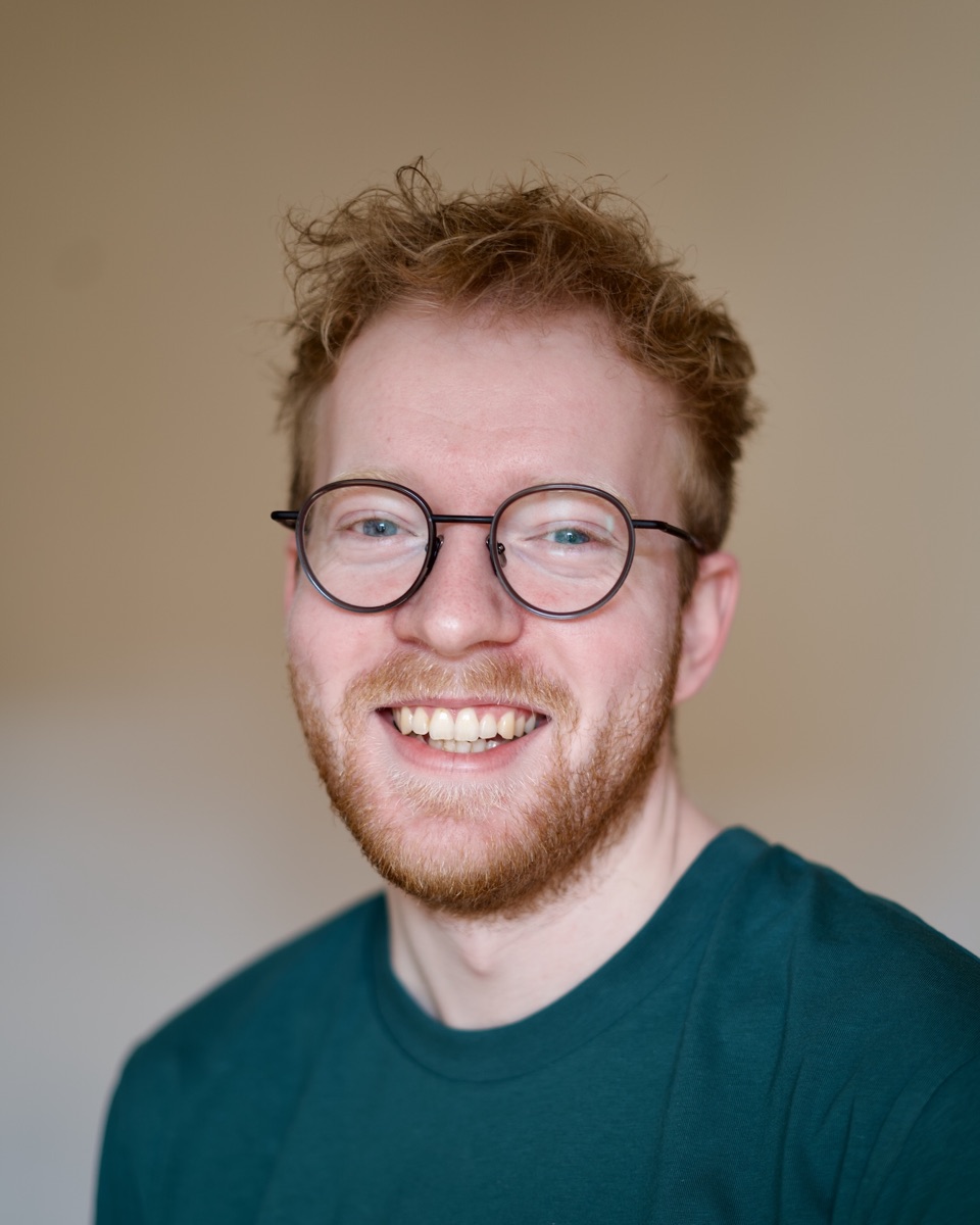 Mikael Lognseth smiling, wearing round glasses